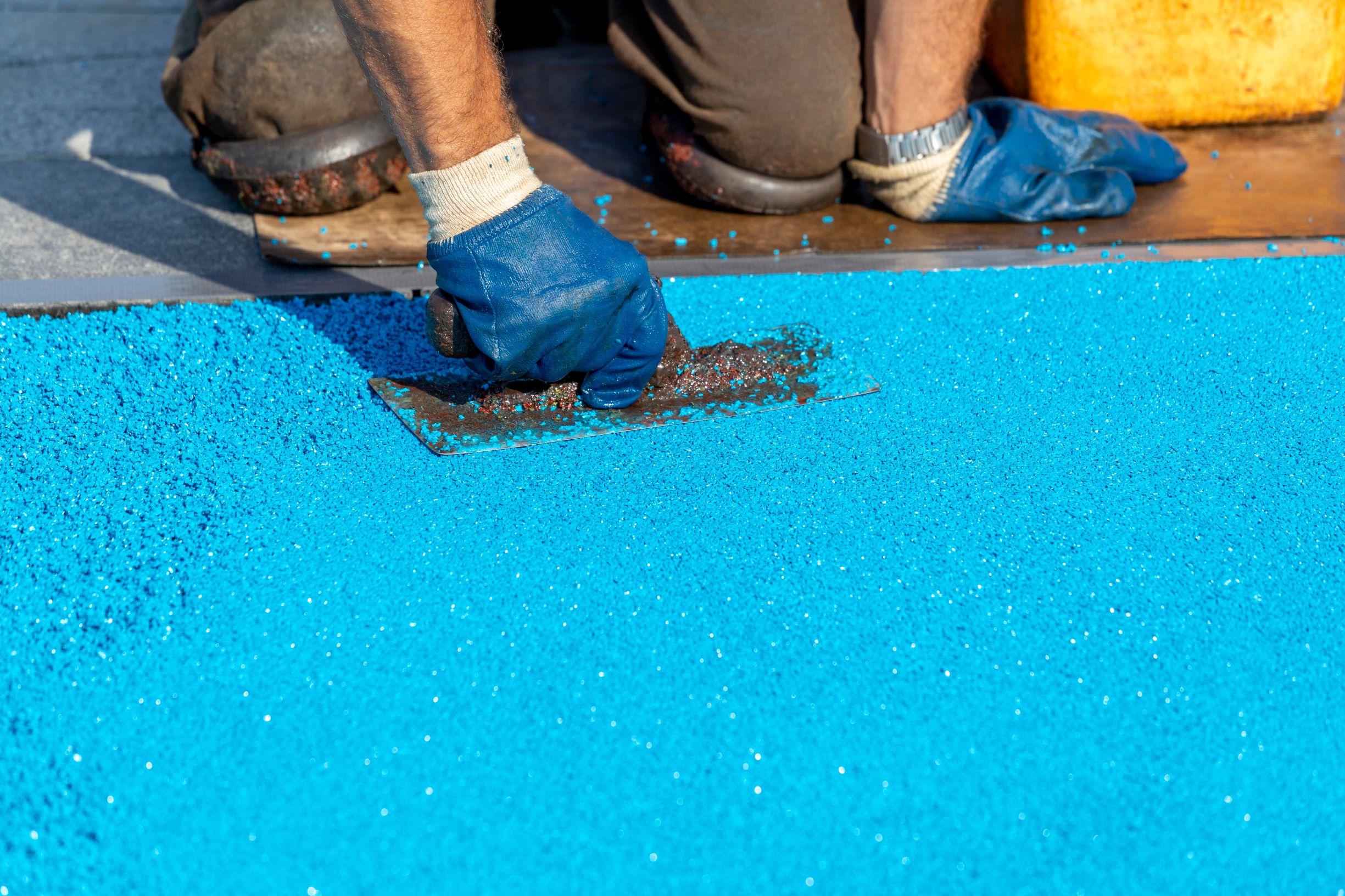 applying bright blue surface coating to a floor 2026 03 26 07 49 32 utc