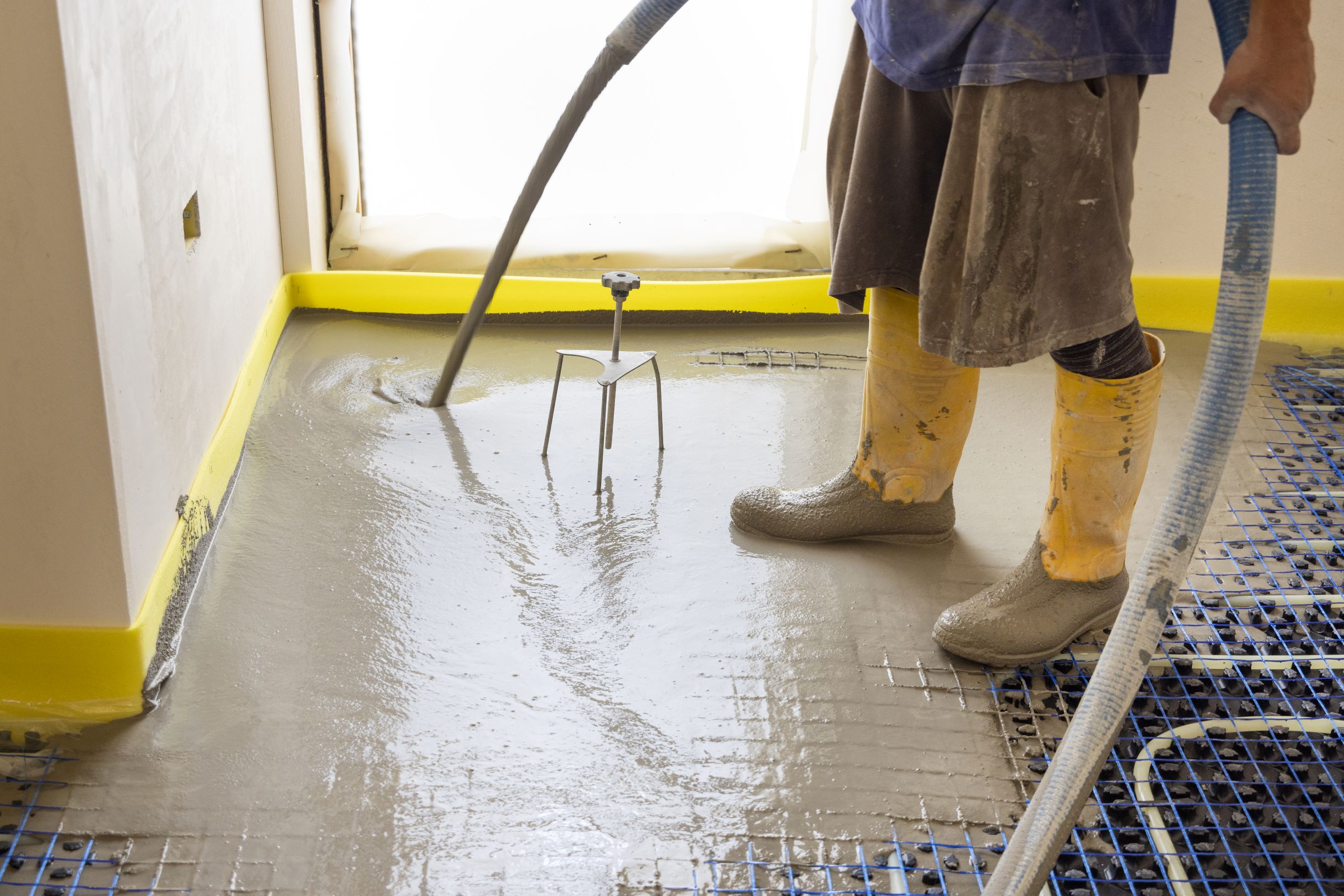 man pouring concrete over floor heating installati 2026 03 25 05 12 54 utc